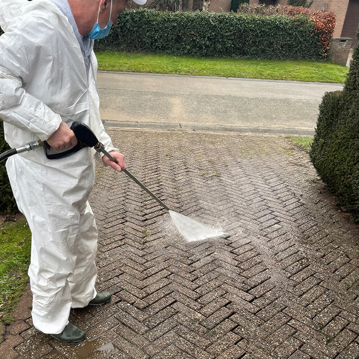 Paved driveway during high-pressure cleaning, the light strip is the part already cleaned.